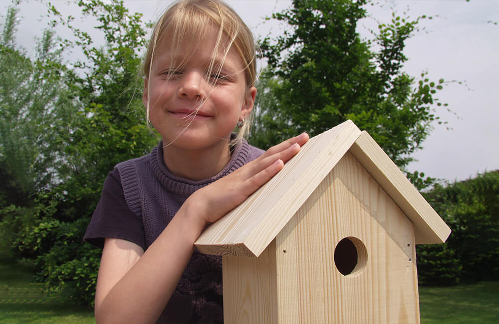 Kind lacht bij het presenteren van het in elkaar gezette nestkastje